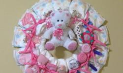 All items are 100% usable (no glue used) and made from a smoke-free home.
One pink and one green wreath is available both include: 14 size 2 diapers to give the new mom a few weeks to hang until the diapers are needed, a small plush bear, onesie, bib, 3