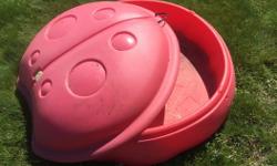 Children's sand box. Red plastic. Aprox 3ft across. Lady bug decorative lid.