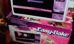 Easy Bake Oven Works perfect, with instructions, pan, lifter/pusher, upper melt pans and cover and comes with box. Last picture shows it lite up (plugged in) You can use regular cake mixes just add a little water and butter the pans. They do sell