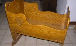 Beautiful handmade cradle for sale. Solid wood ( maple I believe ) with decorations carved in headboard, footboard and sides. Very heavy and sturdy.