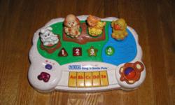 Sing 'N Smile Pals has animals lining the top of the toy. Animals featured include a rabbit, dog, cat and a duck. Each animal has babies with it. The rabbit, dog and cat are sitting on logs in a grassy setting while the duck floats out on the water on a