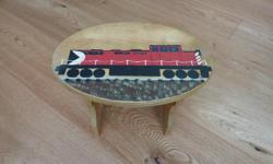 Small wooden stool with hand painted train on top.